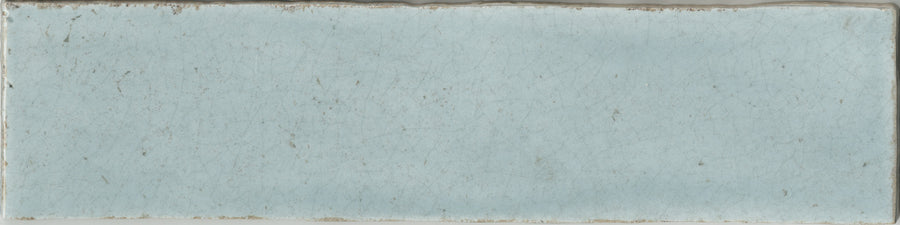 The Maiolica 3x12 Crackled Ceramic Subway Tile features a rectangular, light blue design with a slightly uneven surface, fine crackles, and worn edges for a vintage, weathered look.