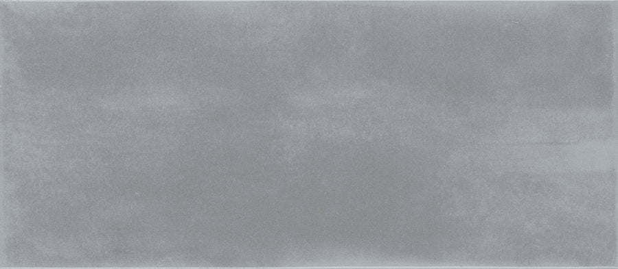 A close-up of a plain, smooth, light gray surface with subtle texture and soft, cloudy patterns evokes the luxury of Maiolica 4x10 Ceramic Subway Tile.