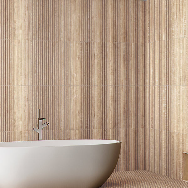A modern bathroom featuring a white freestanding bathtub, a sleek silver faucet, and walls covered with vertical beige textured tiles.