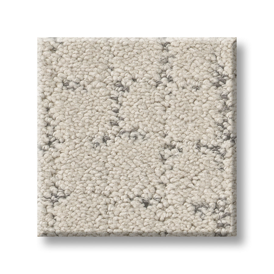 A square sample of Block Party Family Friendly Carpet features an elegant, light beige color with a soft, textured loop pile and subtle dark gray flecks.
