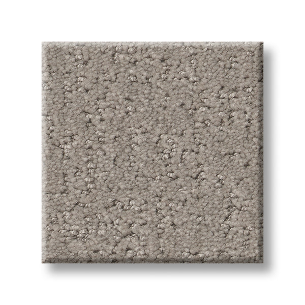 A square sample of Canvas Comfort Blue Family Friendly carpet, light brown with a textured mix of small loops and cut fibers, shown against a white background.