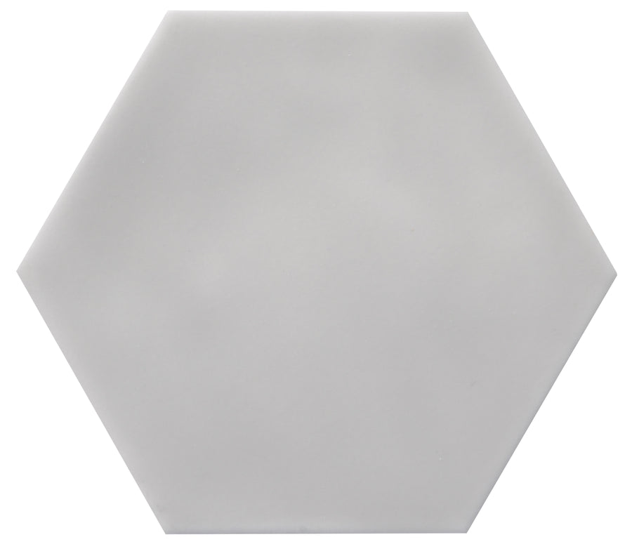 The Zephyr 4.2x4.9 Hexagon Ceramic Tile is a plain, light gray tile with a smooth surface, hexagon shape, and is perfect as a special-order for Mediterranean-inspired spaces. Shown against a white background.