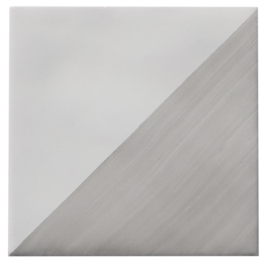 The Zephyr 4x4 Compass Deco Ceramic Tile features a diagonal split: the upper left is smooth light gray, while the lower right displays a textured, brushed metallic silver finish for an artisanal touch.