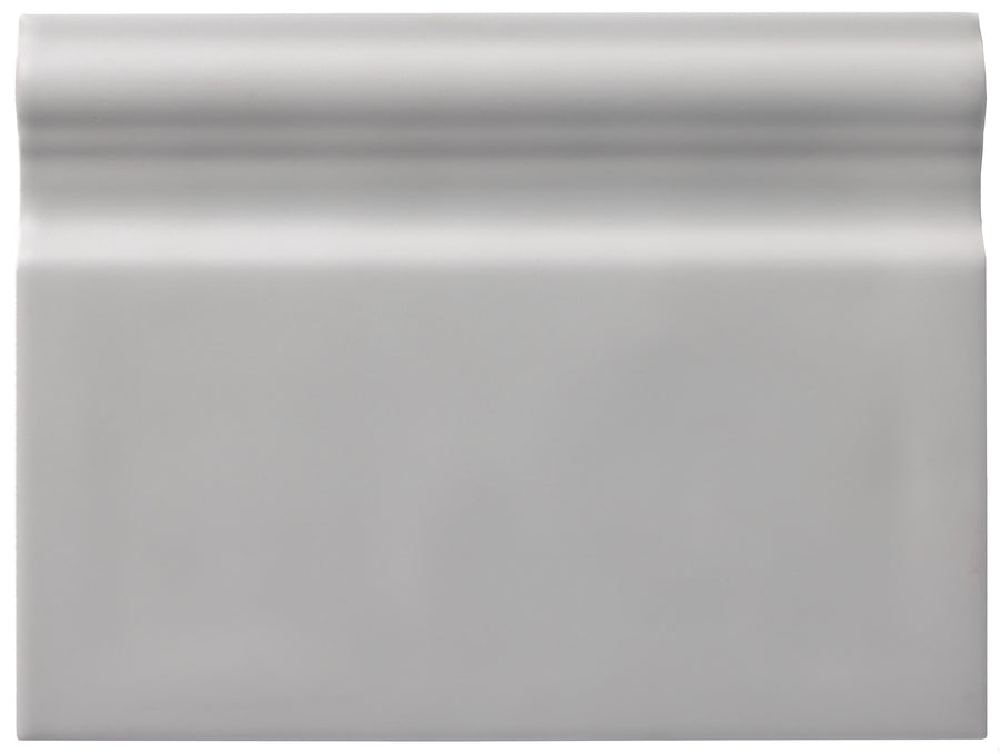 The Zephyr 6x8 Ceramic Baseboard is a rectangular, light gray tile with a raised, rounded top edge and a smooth matte finish—ideal for special-order collections desiring handcrafted Mediterranean-inspired luxury.