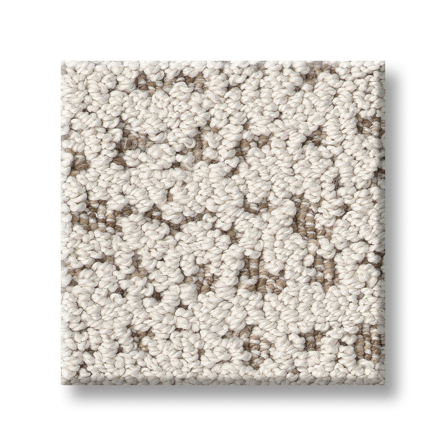 A square sample of Tangent On Trend Carpet in a textured loop-pile with light beige and taupe fibers is shown on a white background, highlighting its luxurious style.