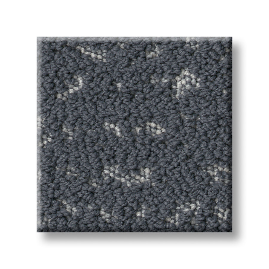A square sample of Tangent On Trend Carpet features a textured gray surface with light and dark speckles, highlighting its stylish, contemporary look against a white background.