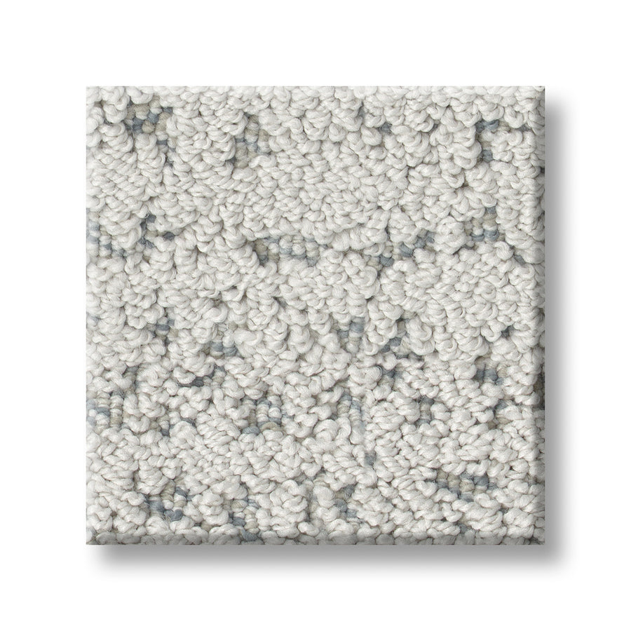 A close-up of Tangent On Trend Carpet shows a square sample in light gray with small, looped fibers and subtle dark gray speckles, displayed against a white background.