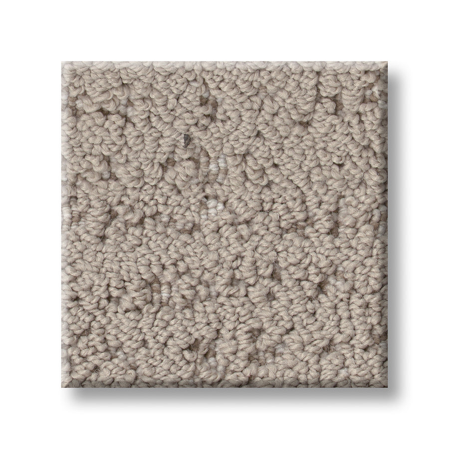 A square sample of Tangent On Trend Carpet, featuring a light beige color and tightly looped textured fibers, is displayed against a white background to highlight its modern design.
