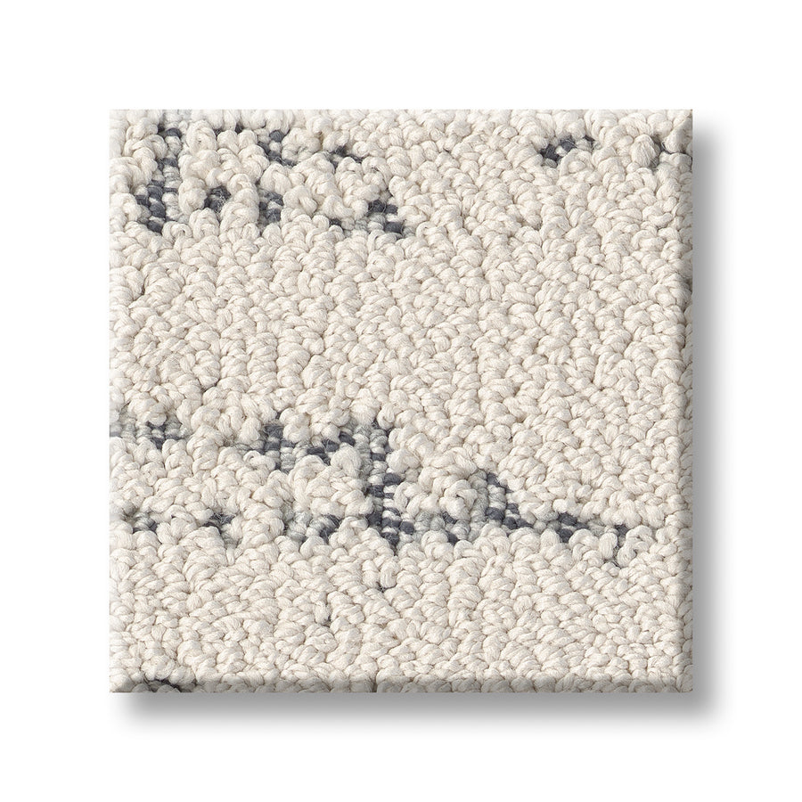 A square sample of Discover On Trend Carpet features off-white textured fibers with subtle gray speckles, highlighting its luxury and contemporary style on a plain white background.