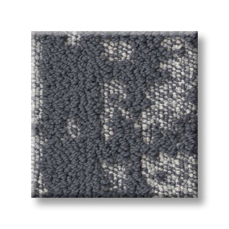 Close-up of a Discover On Trend Carpet swatch featuring a luxury, textured looped pattern in gray and off-white with a mottled, abstract design. Displayed on a white background with a subtle shadow.