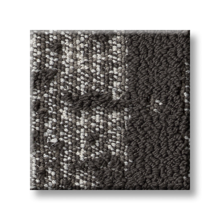 Discover On Trend Carpet is a square tile sample with dark and light gray textured fibers in a subtle geometric pattern, combining loop and cut pile finishes for a luxurious, contemporary style.