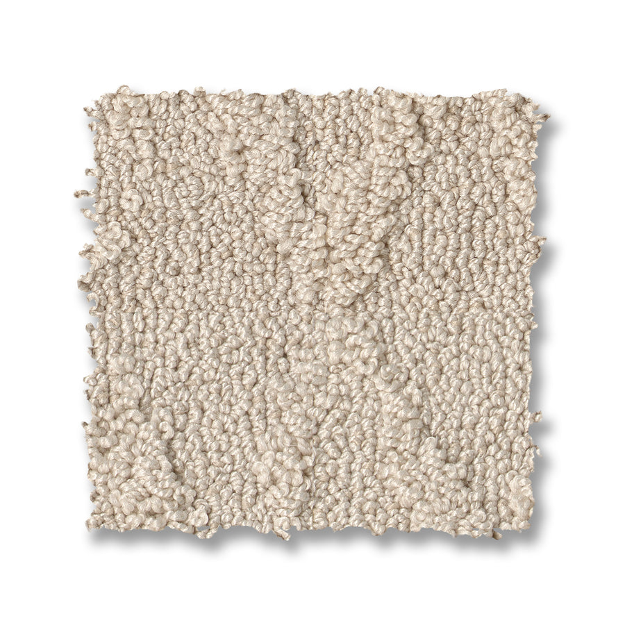 A square swatch of Illumination On Trend Carpet in light beige with looped, textured fibers is displayed on a white background. The slightly uneven edges emphasize the carpet’s plush, premium look.