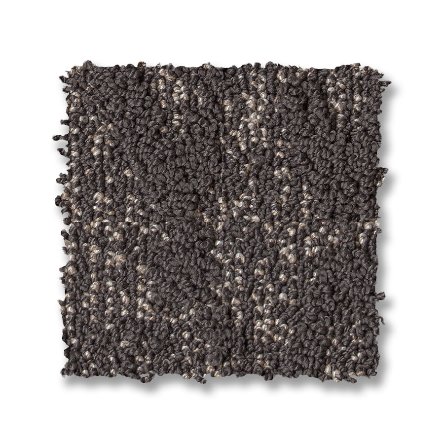 A square swatch of Illumination On Trend Carpet in premium dark gray with lighter flecks sits on a white background—ideal for adding luxury and modern style to any space.