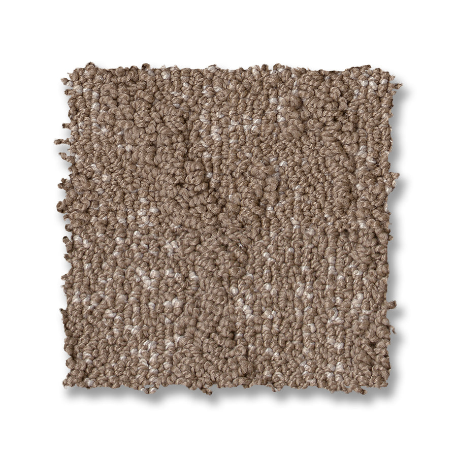 A square sample of Illumination On Trend Carpet is displayed against a white background, featuring light brown, textured loop-pile fibers that appear soft and tightly woven.