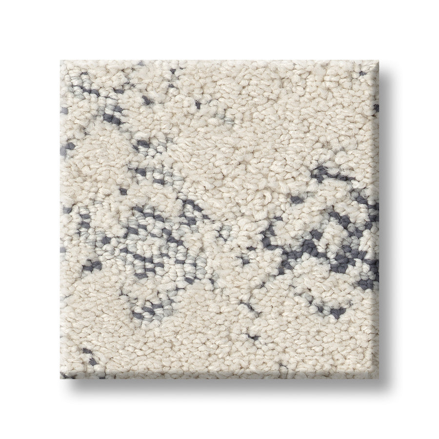 A close-up of Evoke On Trend Carpet reveals soft, cream textured fibers with a subtle gray abstract pattern, creating a plush and inviting look ideal for adding warmth to any room.