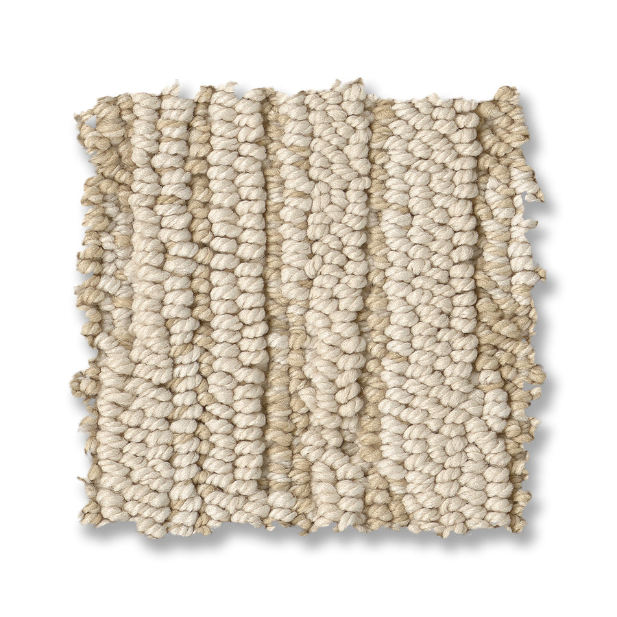 A square swatch of Loom Berber Carpet displays textured, looped beige fibers with a chunky woven pattern and visible yarn strands on a white background, highlighting its sophisticated style.