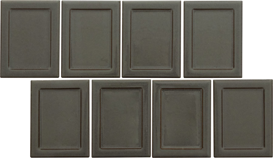 Eight Marco and Polo 4x5 Glossy Porcelain Tiles in Marco Coal are arranged in two rows, with the bottom left tile offset, each featuring a subtle inner rectangular border for a refined, designer-inspired look.
