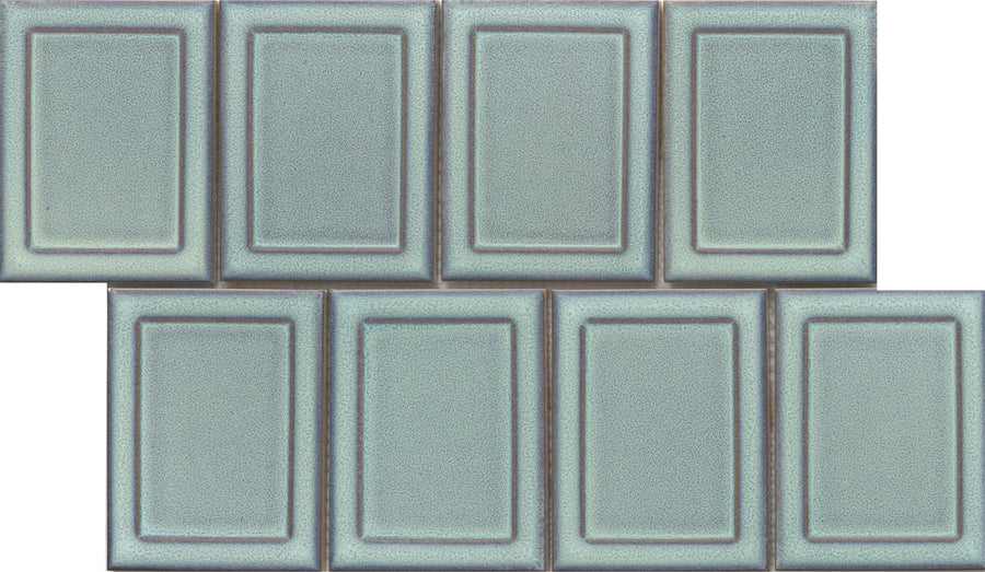 Eight Marco and Polo 4x5 Glossy Porcelain Tiles in Marco Horizon are arranged in two rows of four, with the top row slightly offset. The tiles have a framed profile, raised borders, and a glossy light blue-green finish.