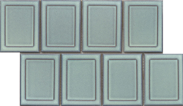 Eight Marco and Polo 4x5 Glossy Porcelain Tiles in Marco Horizon are arranged in two rows of four, with the top row slightly offset. The tiles have a framed profile, raised borders, and a glossy light blue-green finish.