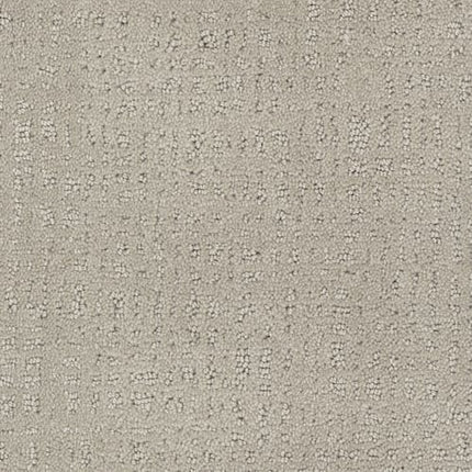 Close-up of Homage Berber Carpet in Marrakech—a textured, light gray material featuring a subtle dotted and raised linear pattern, perfect for adding modern, understated style to high-traffic spaces.