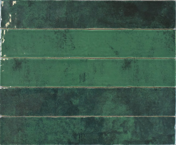 Five Marrakesh 2x16 Ceramic Tiles, rectangular and glossy green, arranged horizontally in a grid with subtly mottled coloring from dark emerald to light green and a gently textured surface.