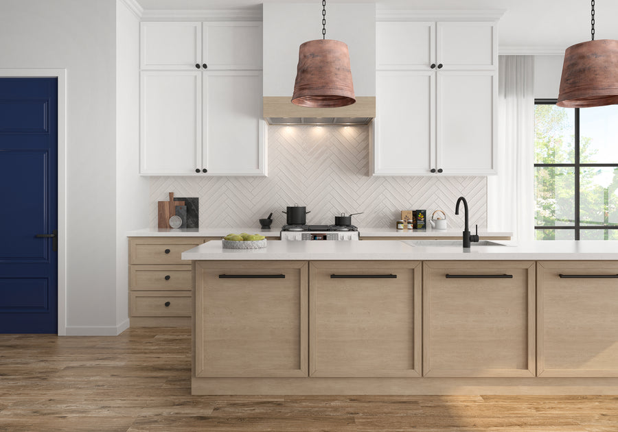 Modern kitchen with light wood lower cabinets, white upper cabinets, a white herringbone tile backsplash, black fixtures, a gas stove, two copper pendant lights, and a large window letting in natural light.