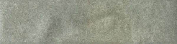 A close-up of the Menagerie 2.5x9.5 Porcelain Tile shows its smooth, pale gray surface with subtle handmade texture and gentle, uneven shading.