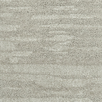 Close-up of Cirrus Berber Carpet in Mist, featuring a light grey hue with a textured, wavy pattern and plush, dense fibers. Its softly mottled look brings elegance and comfort to any space.