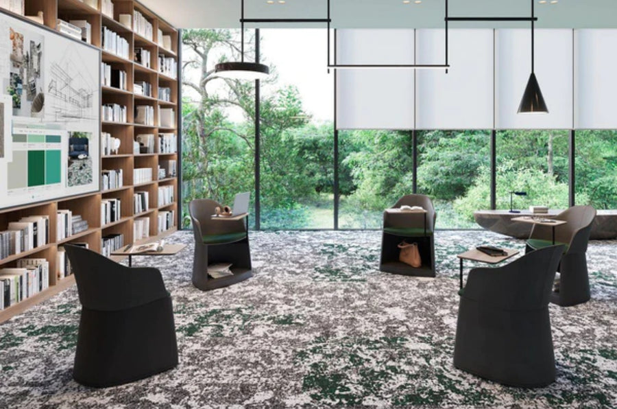 Modern meeting room with four black chairs, bookshelves, and a large window with green views. The commercial space showcases natural light and stylish Commercial Modular Carpet Tiles in gray and green patterns.