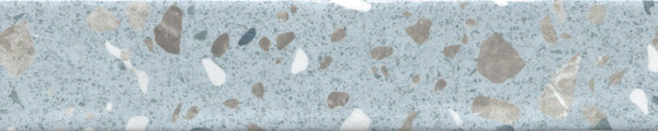 The Fragmento 2x10 Ceramic Tile in Mr. Blue Skies features a light blue-gray base with irregular beige, brown, and gray speckles for a terrazzo-stone look—ideal for wall tiles seeking a subtle yet bold pattern.