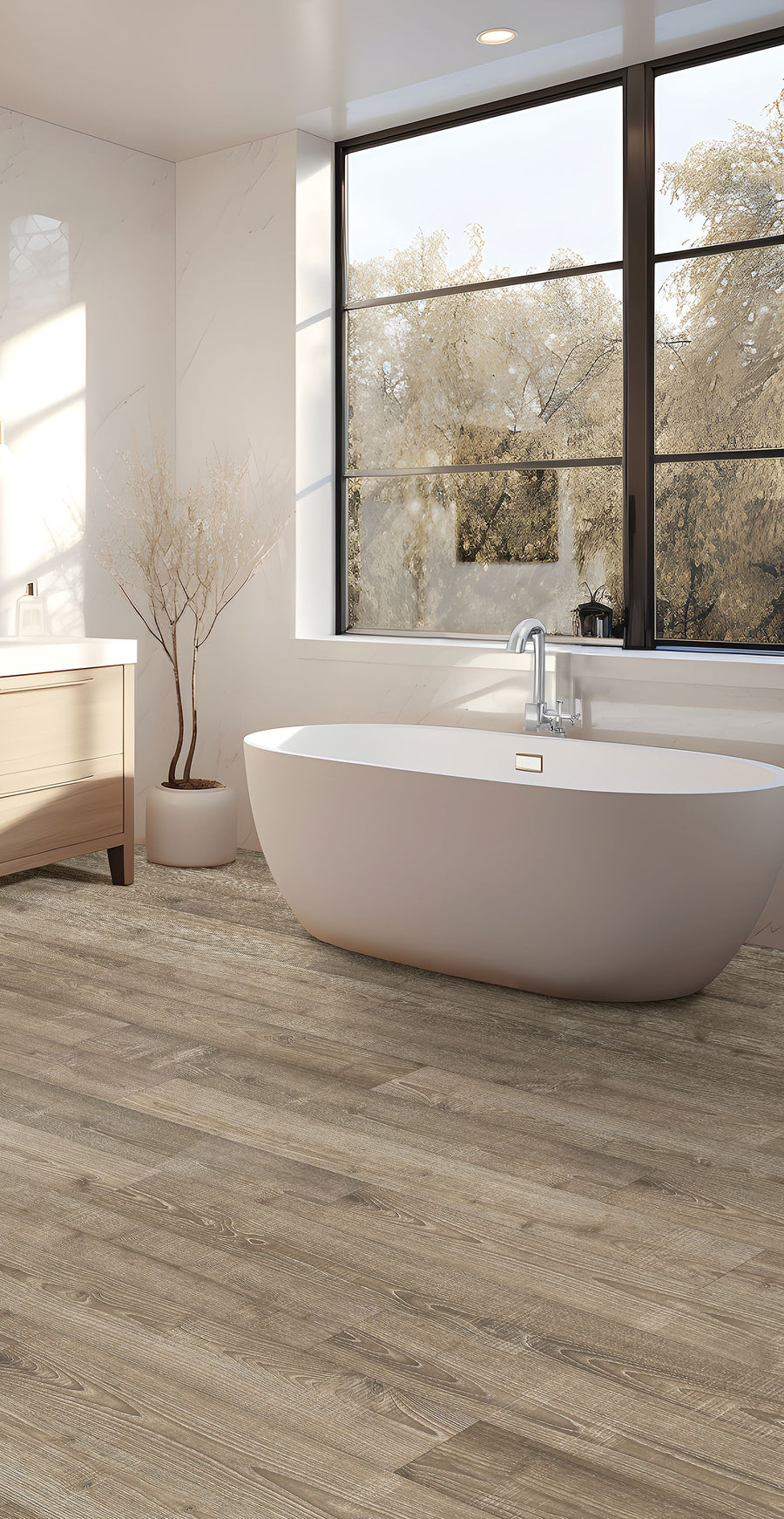 Modern bathroom with a freestanding white bathtub, large window showing trees outside, wooden vanity with a white countertop, and light wood plank flooring. Neutral tones create a calm, spa-like atmosphere.