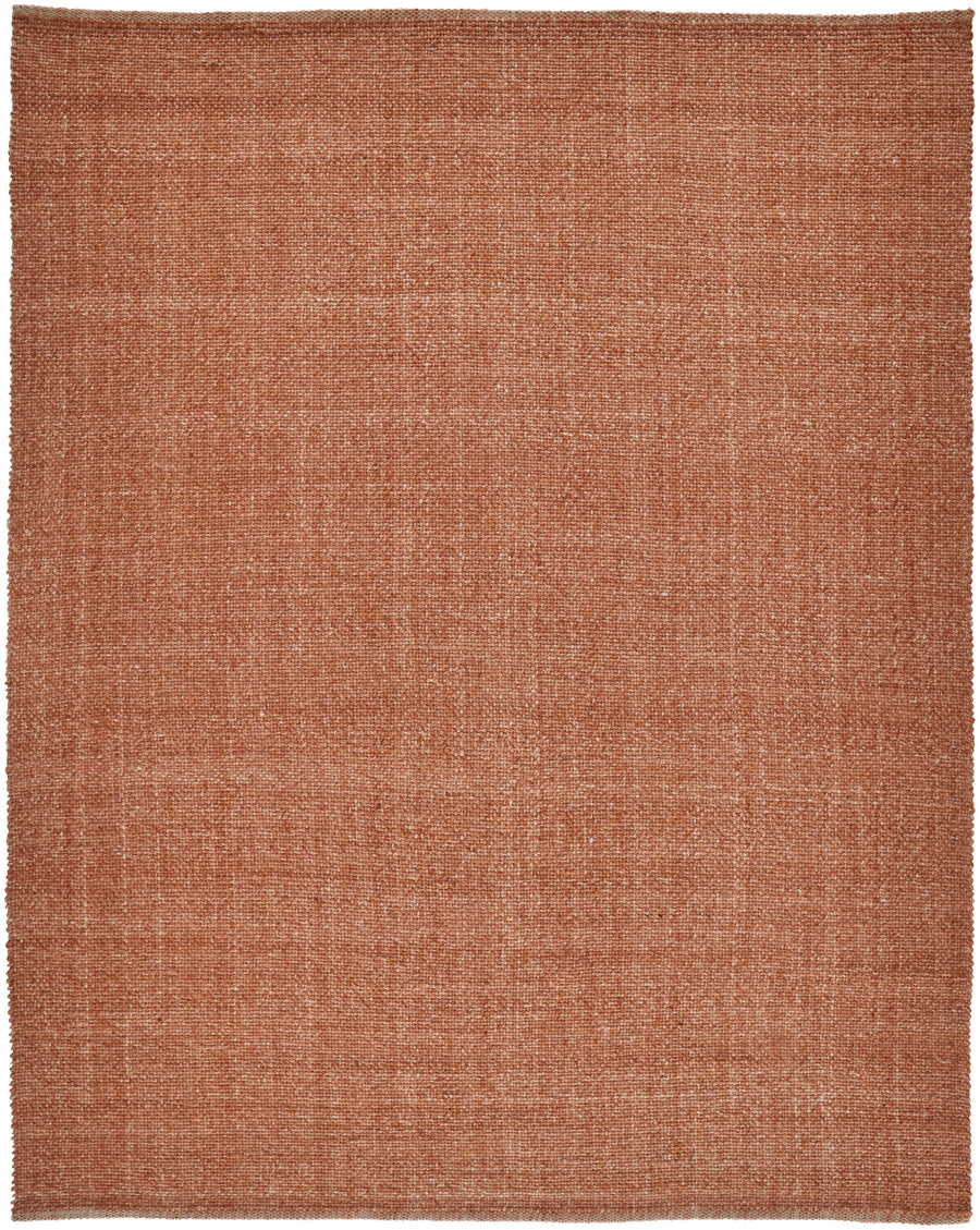 The Naples Area Rug, a large square piece in warm terracotta, features a subtle woven pattern and slightly uneven edges for an elegant accent in any room.