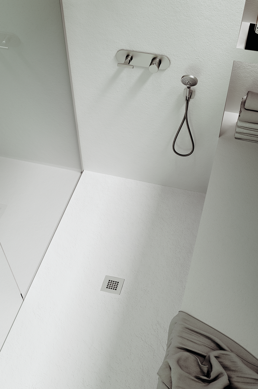 Minimalist bathroom with modern overhead and handheld showers, wall-mounted fixtures, folded towels on a shelf, and the NEOStone Point Center Drain Shower Base. Clean lines and a neutral palette finish the sleek, low-profile design.