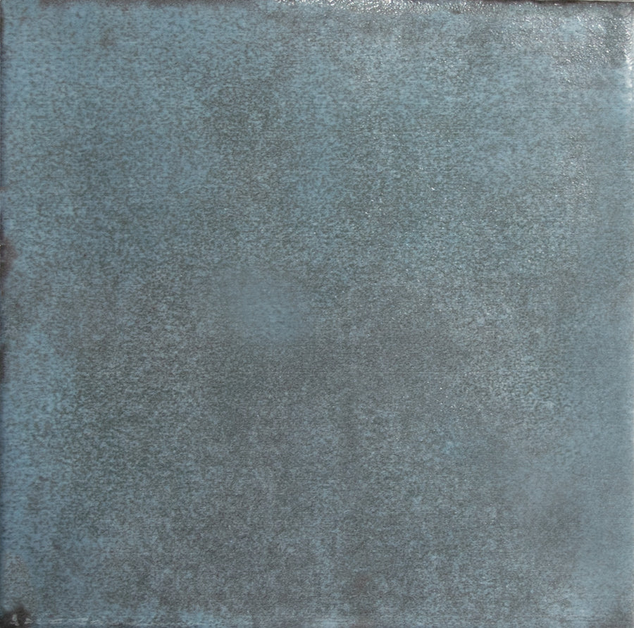 The Nakama 5" x 5" Ceramic Tile features a textured, blue surface with mottled tones and slightly darker edges for a weathered, rustic look.