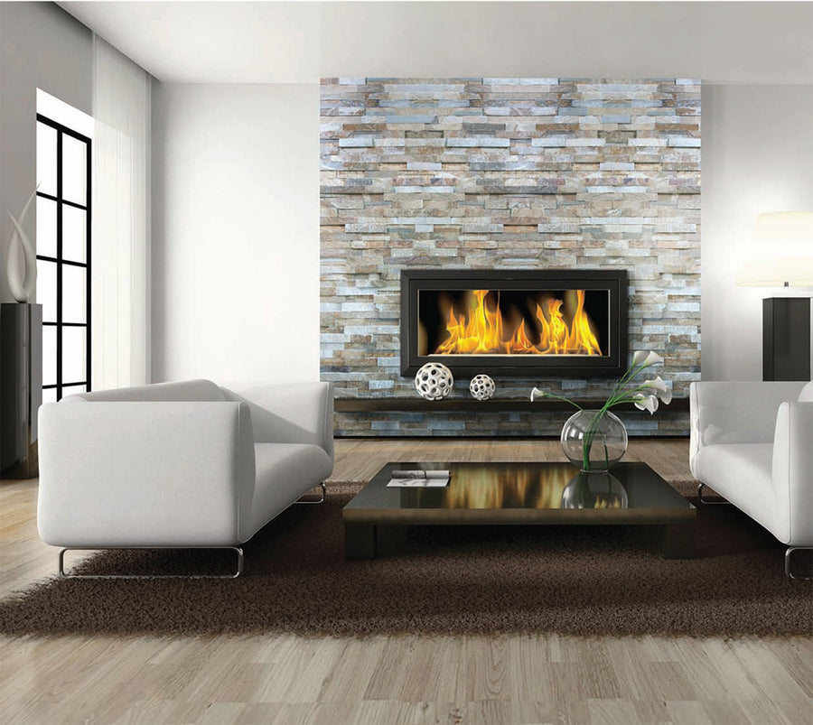 Modern living room with white sofas, a dark coffee table, and a rectangular fireplace set in a stone accent wall. The fire is burning, and decorative items sit on the table and mantel. Large windows provide natural light.