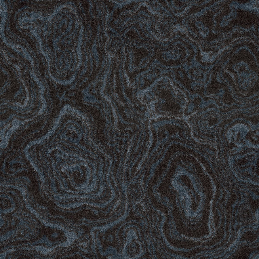 With a dark, textured surface and swirling patterns in black and gray, Nature's Gem On Trend Carpet features an abstract, wood grain-inspired design ideal for modern spaces.