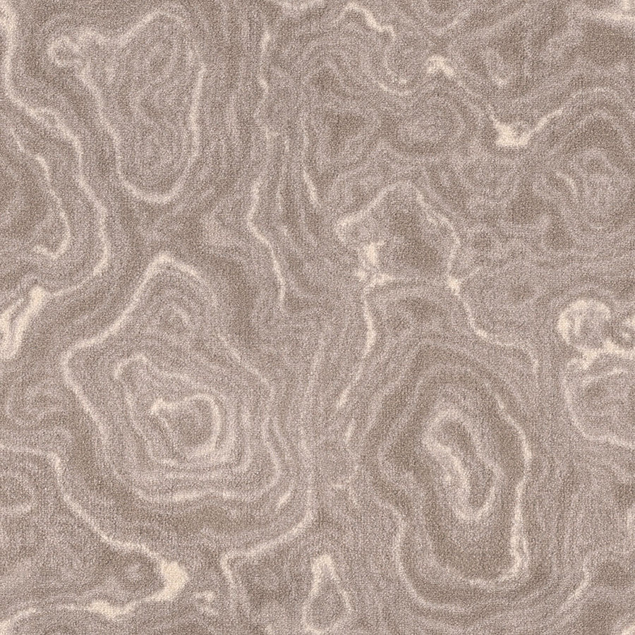 A close-up of Nature's Gem On Trend Carpet reveals swirling, layered patterns in beige and light brown, echoing natural stone or wood grain and highlighting the carpet’s stylish texture.