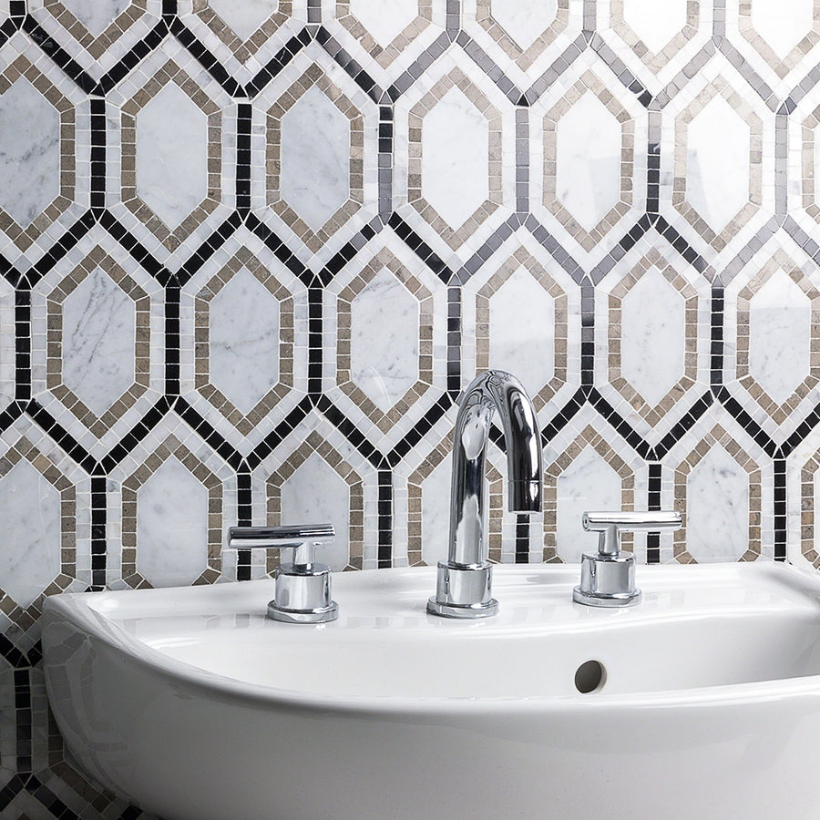 A close-up view of a modern white sink with a chrome faucet and handles, set against a geometric-patterned tile backsplash in white, beige, and black tones.