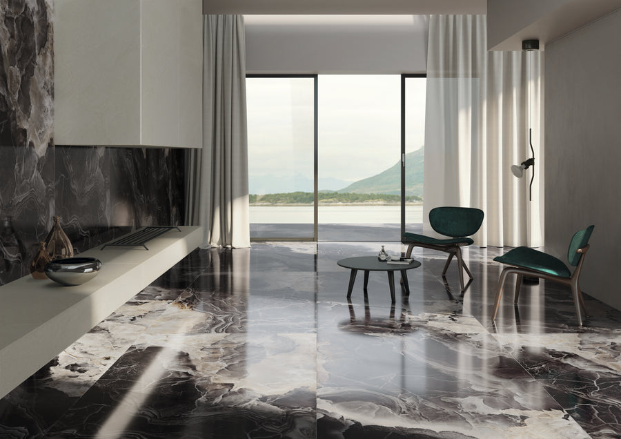 Modern living room with marble floor, minimalist furniture, and large windows revealing a scenic view of mountains and water. The room features a fireplace, two green chairs, a small table, and sheer white curtains.