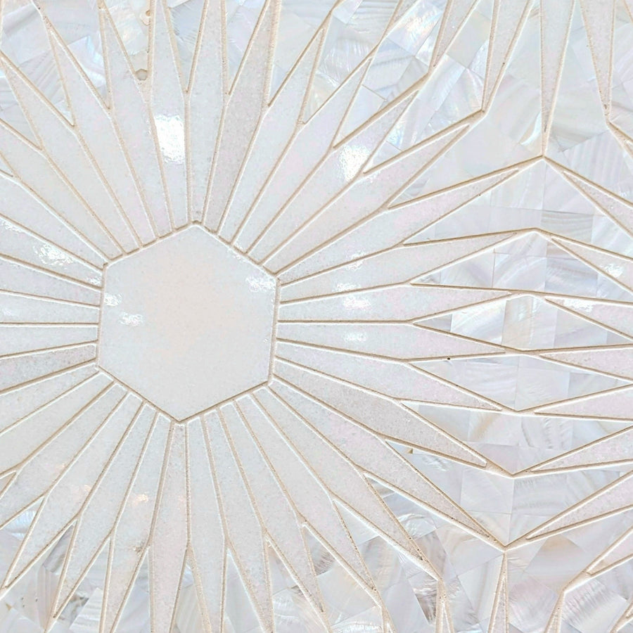The Night Star Polished Marble Mosaic Tile features a geometric design with a central hexagon and radiating triangles in pearly white marble, finished with a glossy, iridescent sheen reminiscent of mother of pearl.