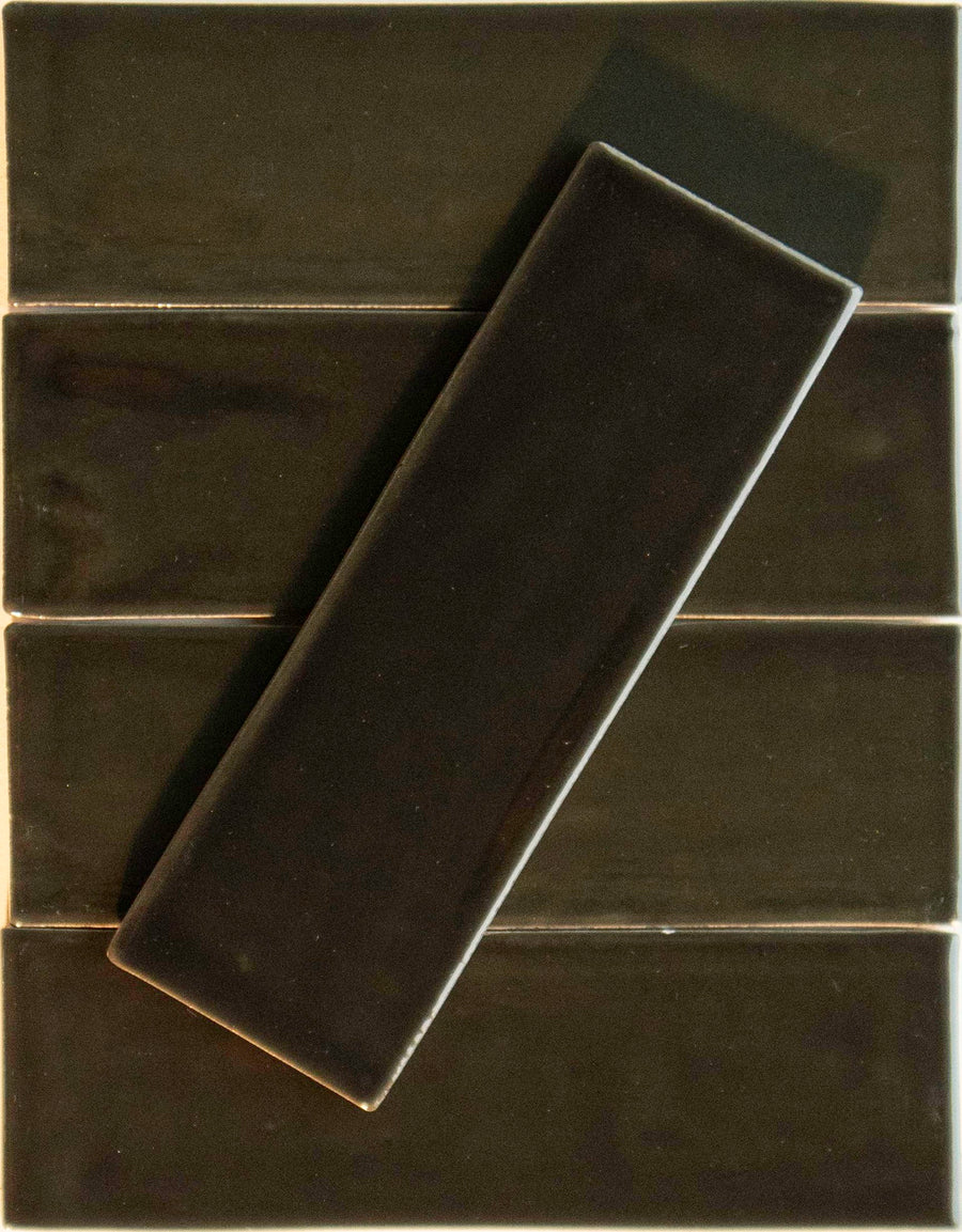 A Noir Crackle 2.5x8 Ceramic Tile in Nightfaling 4 U is set diagonally on four horizontally placed, matching tiles, contrasting direction while keeping a unified color and glossy finish.