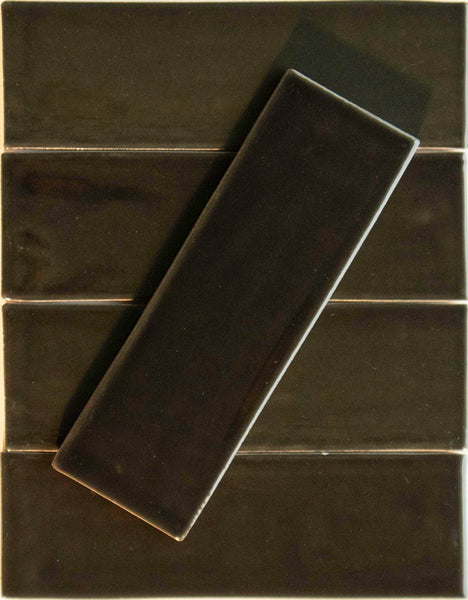 A Noir Crackle 2.5x8 Ceramic Tile in Nightfaling 4 U is set diagonally on four horizontally placed, matching tiles, contrasting direction while keeping a unified color and glossy finish.
