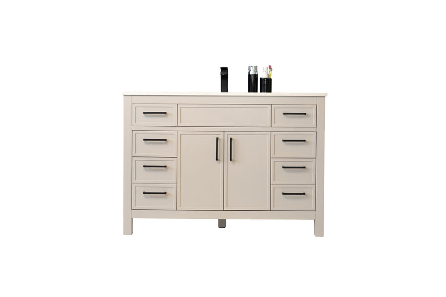 A beige dresser with six drawers, two central cabinet doors, and black handles. Three items, including a black bottle and two glass containers, are arranged on top. The background is plain white.