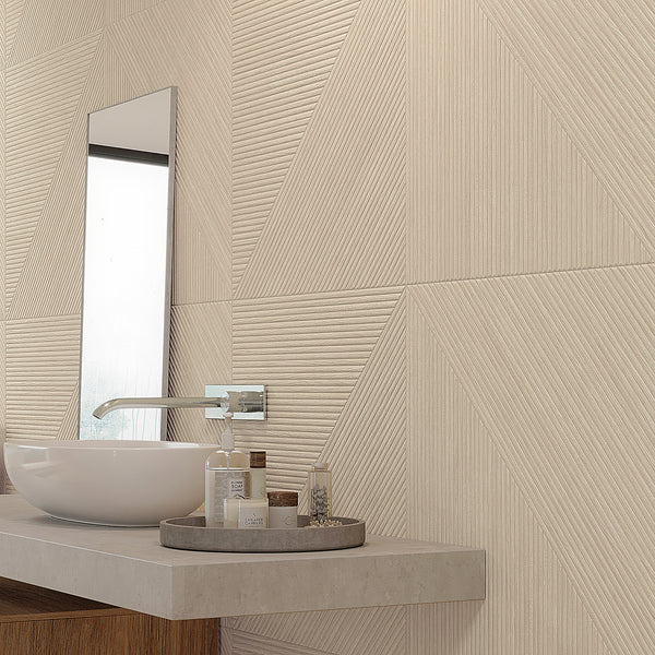 A modern bathroom with a geometric textured beige tile wall, a rectangular mirror, a round white vessel sink, and a tray holding toiletries on a light-colored countertop.