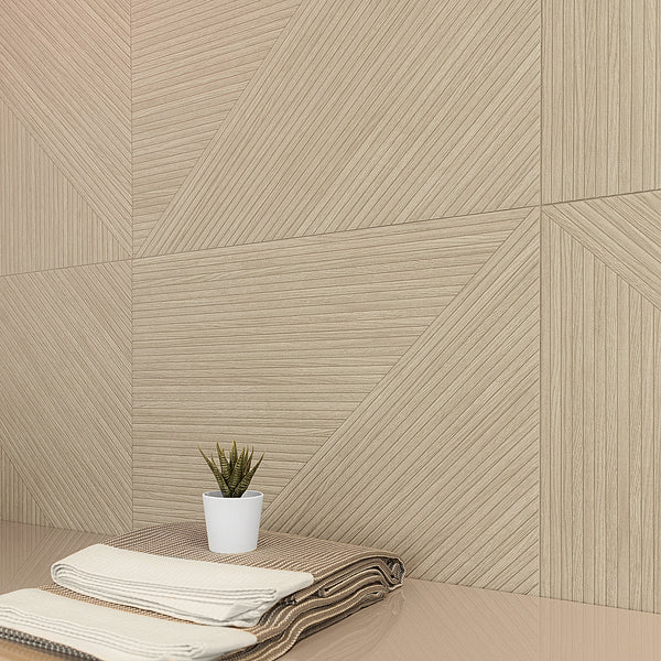 A neatly folded pair of beige and brown towels sits on a glossy surface next to a small potted succulent, with a beige, geometric-patterned wall in the background.