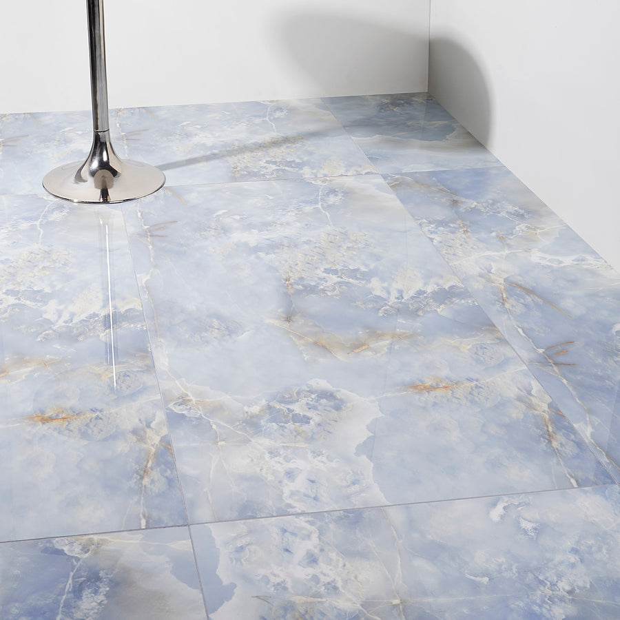 Blue and white marble-look floor tiles with subtle gold veining; a shiny metal table leg is visible on the left side, and the walls are plain white.