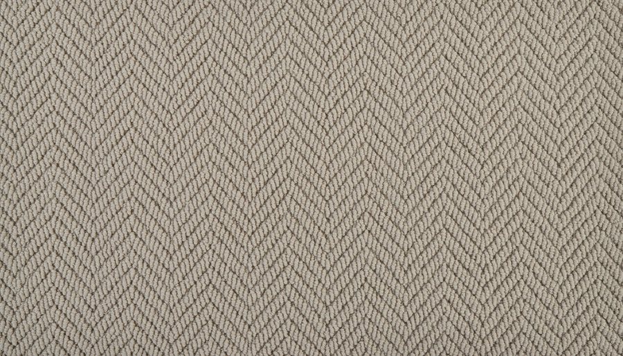 A close-up of the Bespoke On Trend Carpet in beige, showcasing its subtle herringbone pattern with diagonal lines that form an elegant zigzag texture across the surface.