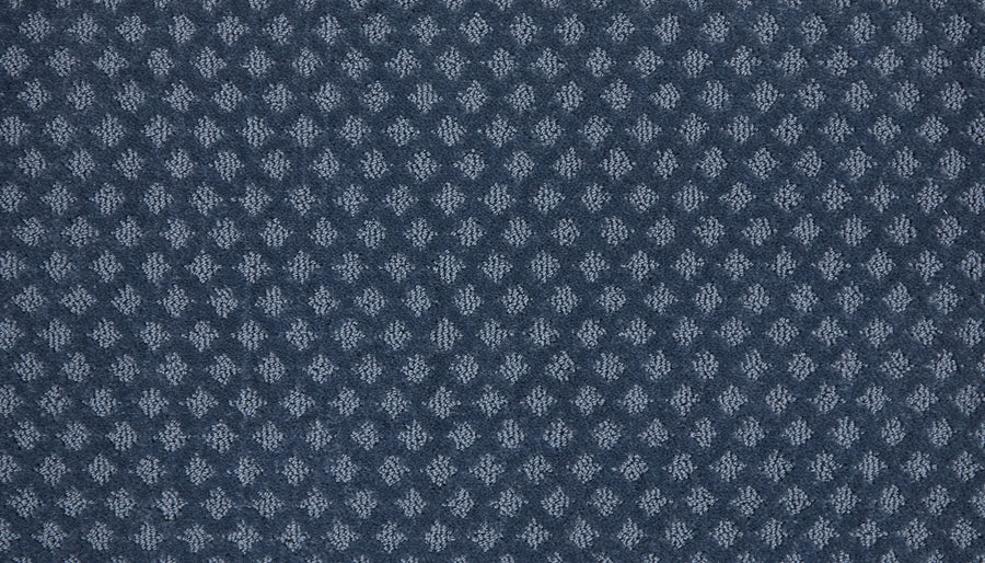 Close-up of Retro Revival Pet Friendly Carpet, showcasing textured dark blue fabric with a repeating small diamond pattern in lighter blue—perfect for luxury interiors.
