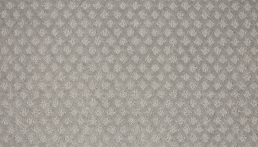 Close-up of Retro Revival Pet Friendly Carpet in light gray, featuring a repeating diamond-shaped raised pattern that adds subtle geometric texture reminiscent of luxury carpet surfaces.