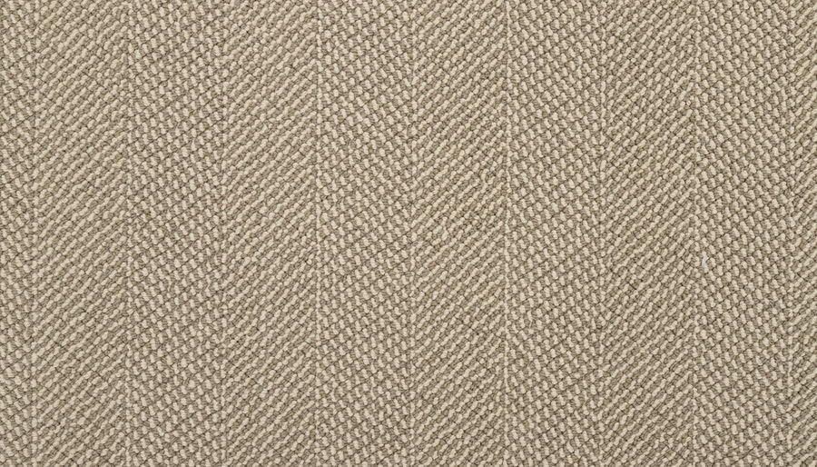 Close-up view of Motley On Trend Carpet’s textured beige fabric with a diagonal herringbone pattern, highlighting detailed woven threads—a stylish and sophisticated flooring choice.